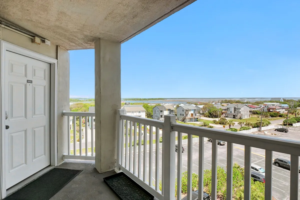 A peaceful balcony scene with an inviting railing and doorway framing the expansive view of the landscape and ocean. The atmosphere is serene, ideal for watching sunrises or sunsets, or enjoying quiet time together outdoors.